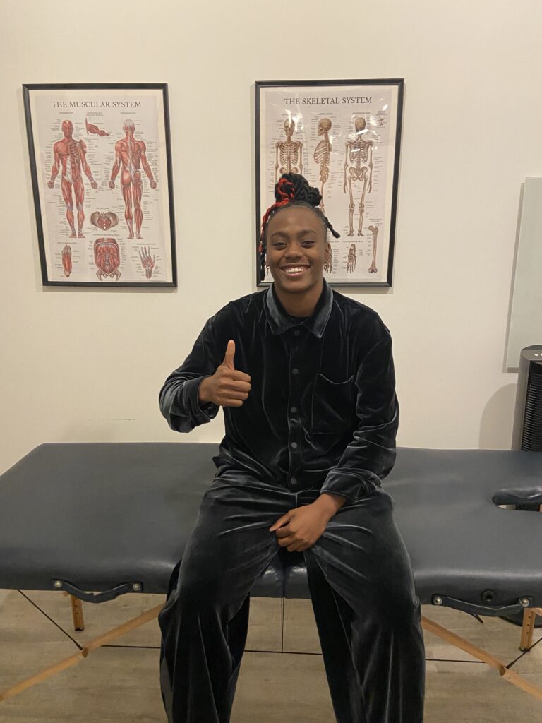 Black female athlete working with a physiotherapist to improve physical performance